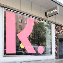 En bild på Klarnas kontor på Sveavägen i Stockholm ett stort rosa K på skyltfönster mot gatan för att illustrerar Klarnas Stiftelse