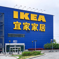 IKEA logotyp på svenska ock kinesiska i gult på ett blått kinesiskt IKEA varuhus för att illustrera IKEAs stiftelser